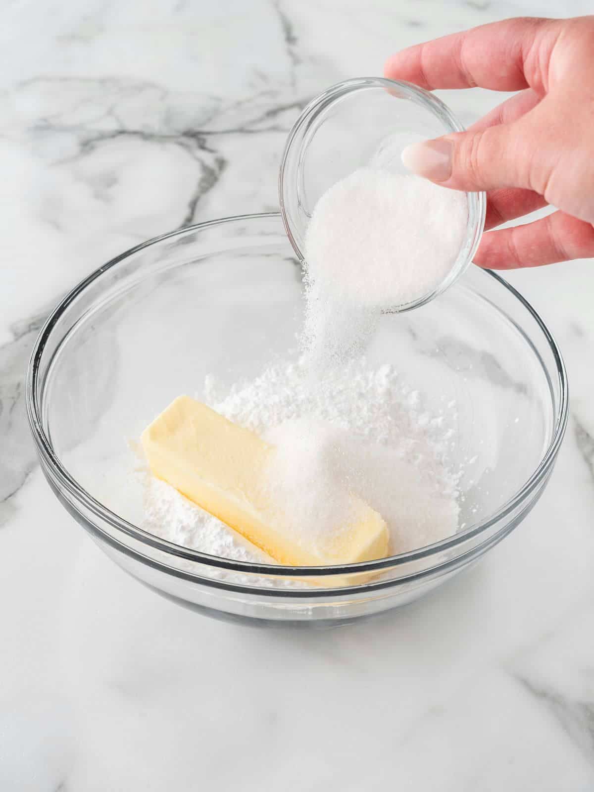 mixing sugar and butter in glass mixing bowl for baseball sugar cookies
