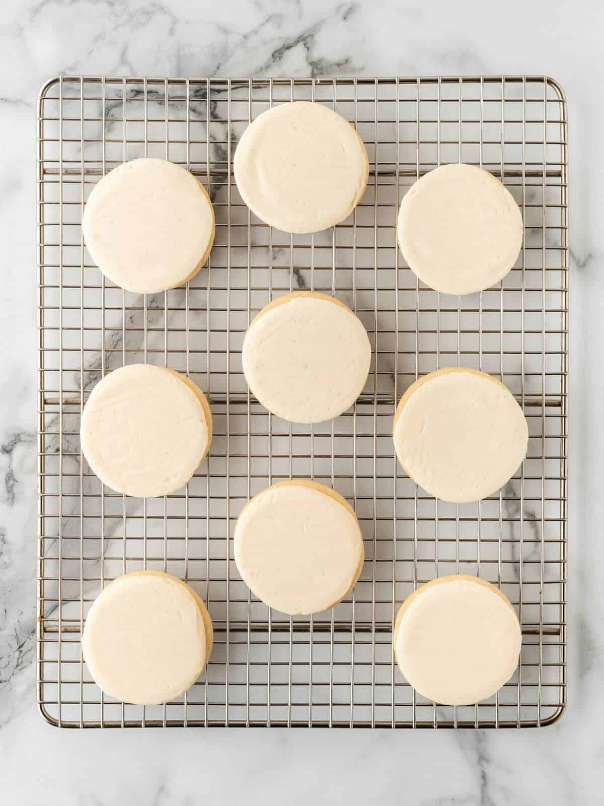 frosted sugar cookies on cooling rack