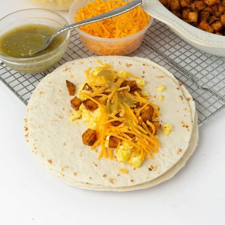 flour tortilla with burrito ingredients in the center