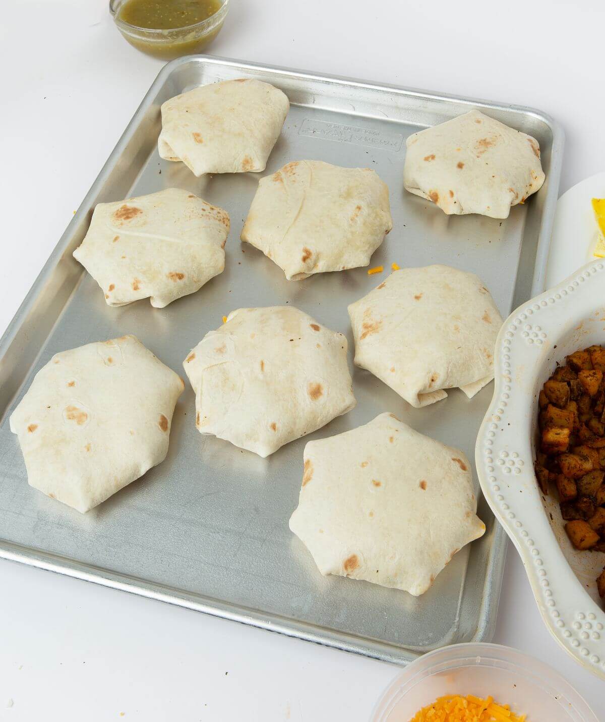 eight folded breakfast crunchwraps on baking tray