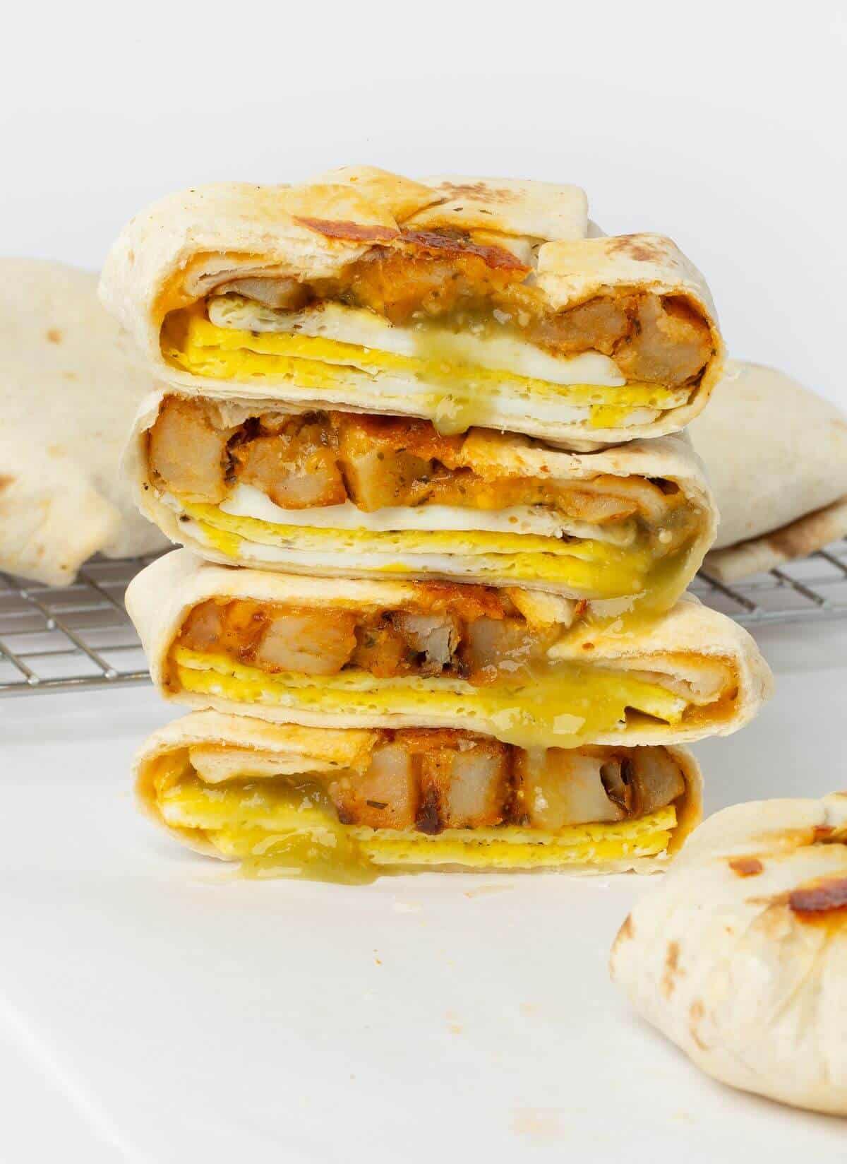 two breakfast crunchwraps cut in half stacked on top of each other