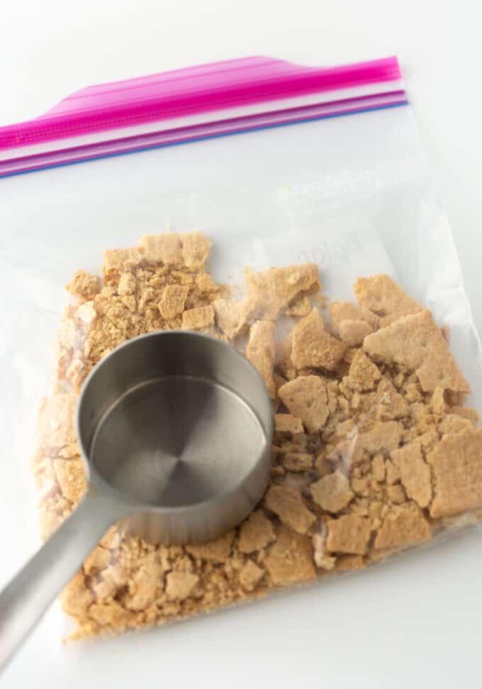 crushing graham crackers in plastic ziploc bag
