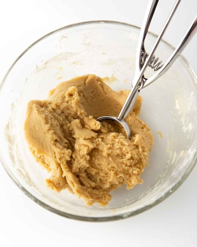 Glass bowl with snickerdoodle cookie dough with 2-tablespoon cookie scoop