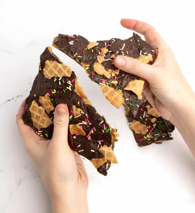 hands breaking apart chocolate peanut butter bark