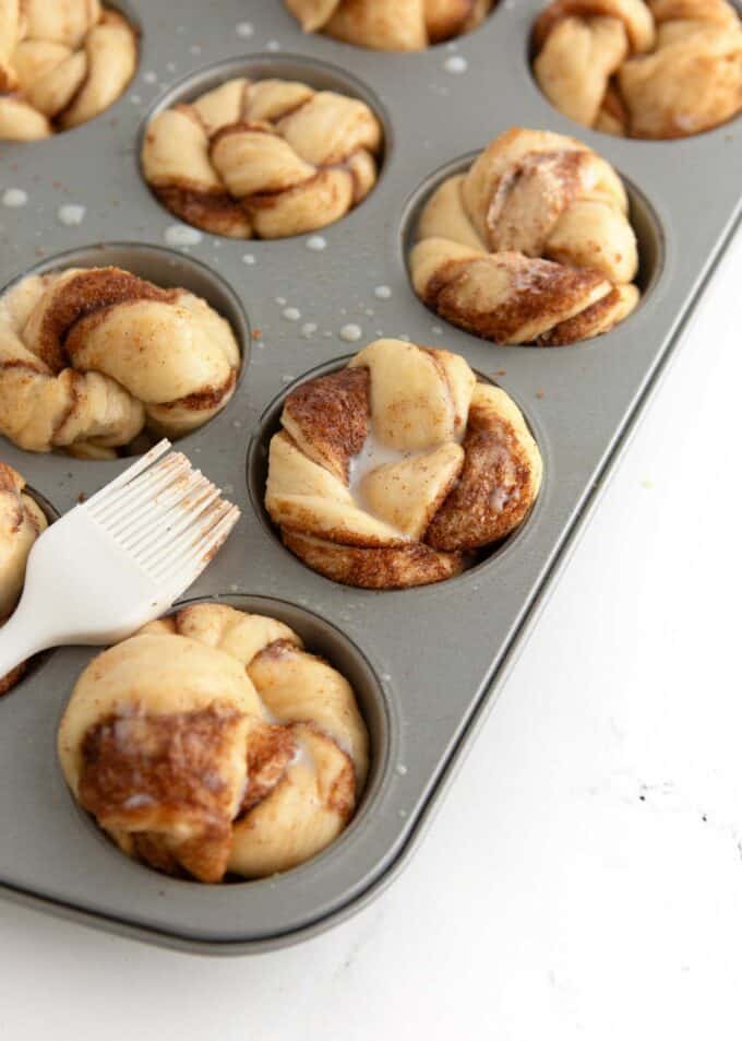 unbaked cinnamon roll muffin dough brushed with milk