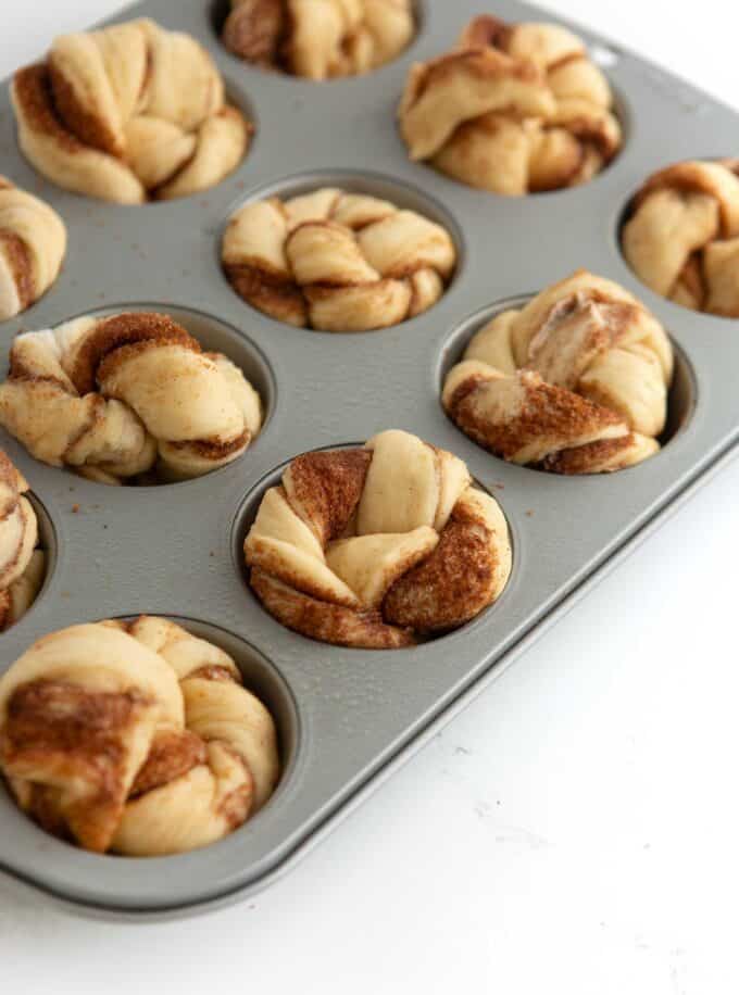unbaked cinnamon roll muffin dough in cupcake pan