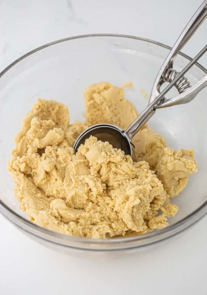 bowl of coconut sugar cookie dough with cookie scoop
