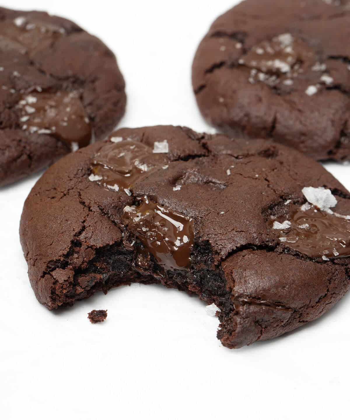 Upclose on dark chocolate chunk cookie with bite taken out.