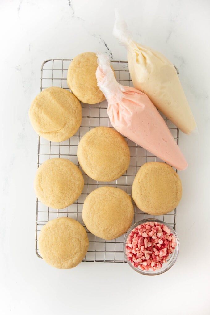 unfrosted peppermint sugar cookies and piping bag on wire rack