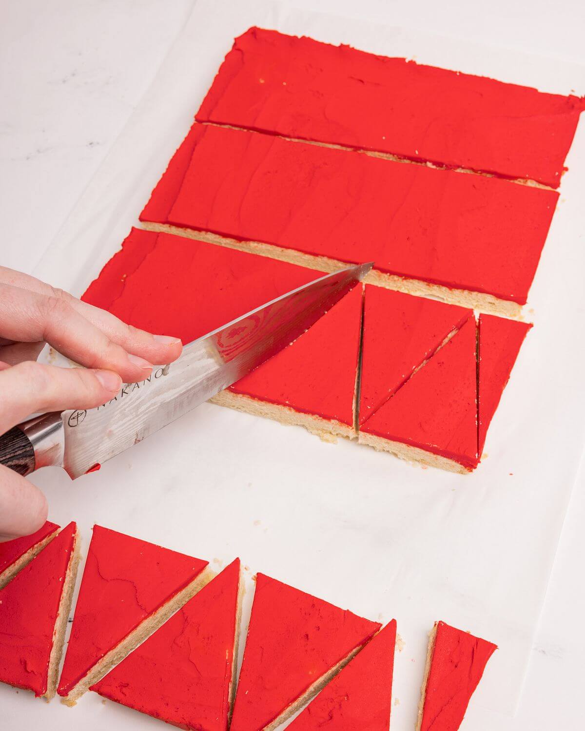 cutting santa hat sugar cookie bars into triangles
