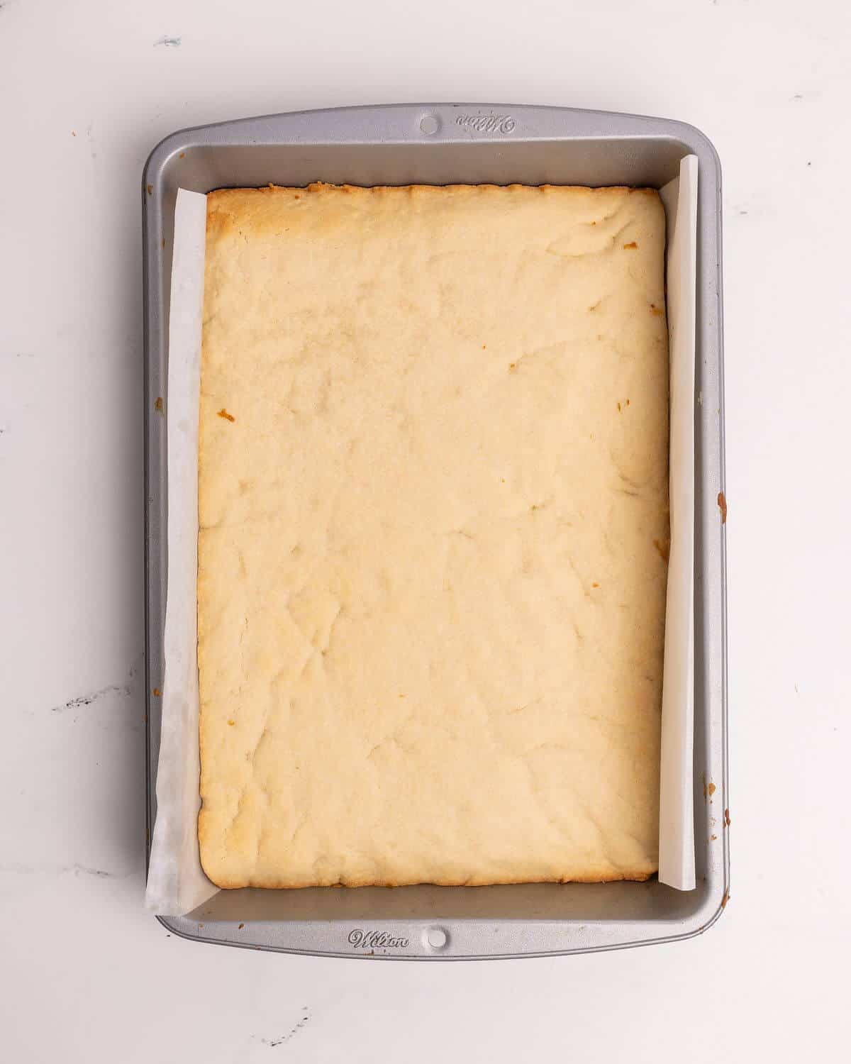 baked sugar cookie bar recipe in 9x13 metal pan
