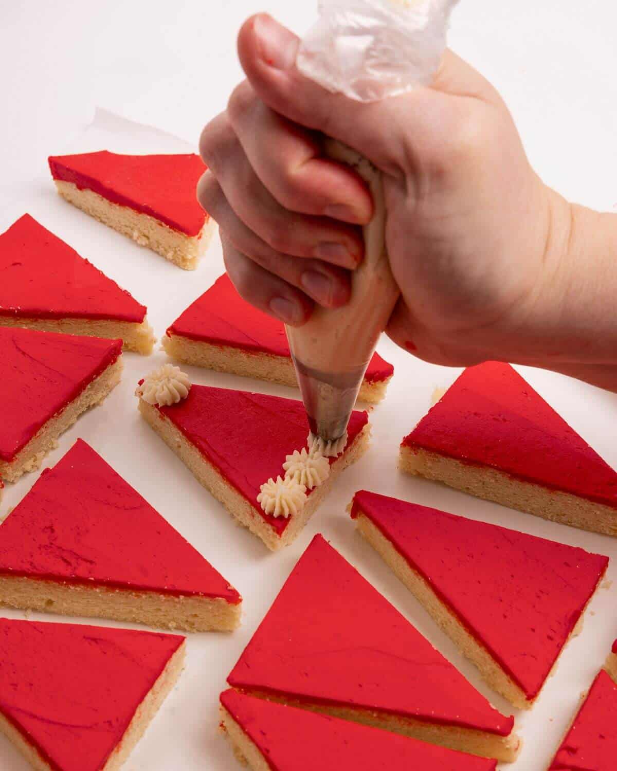 adding white pompoms to red sugar cookie bars