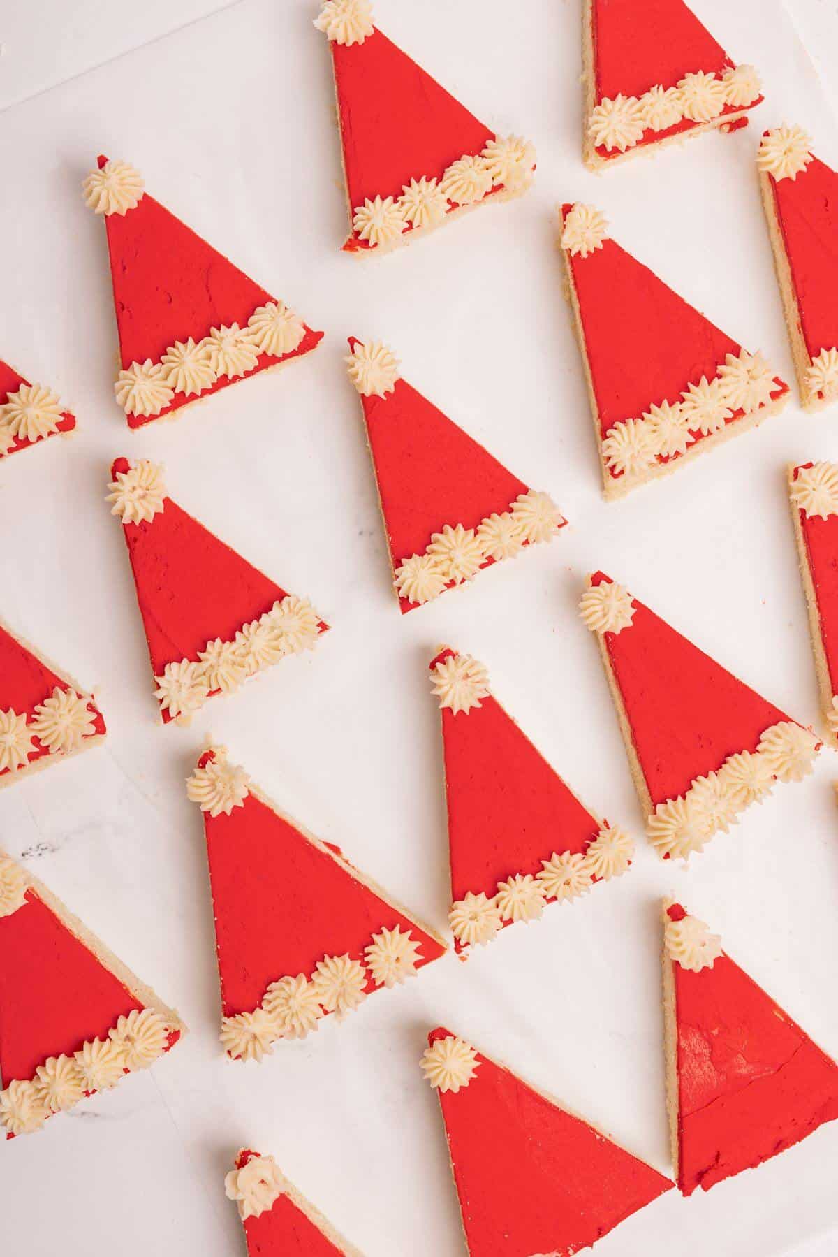 santa hat sugar cookie bars decorated on parchment lined sheet