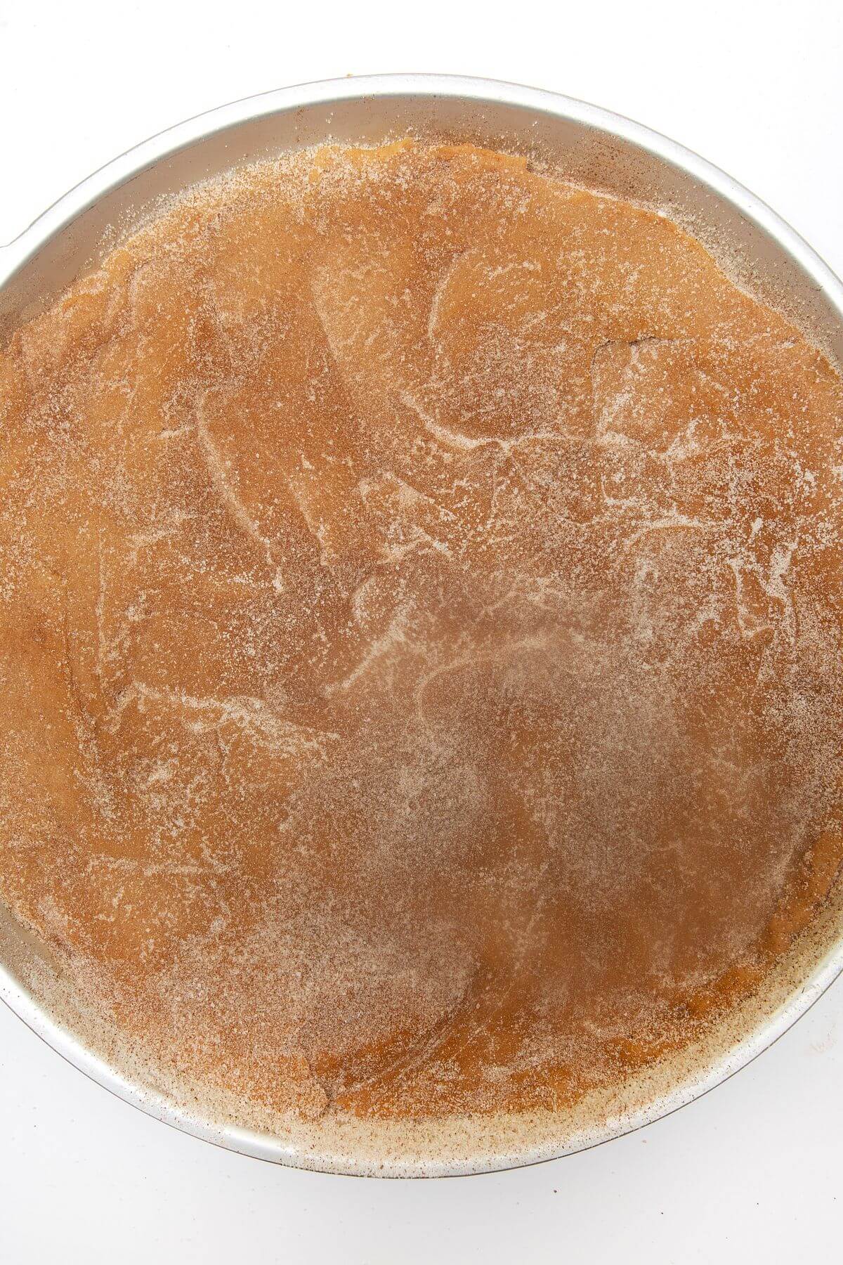 Snickerdoodle cookie cake dough pressed into cookie cake pan.