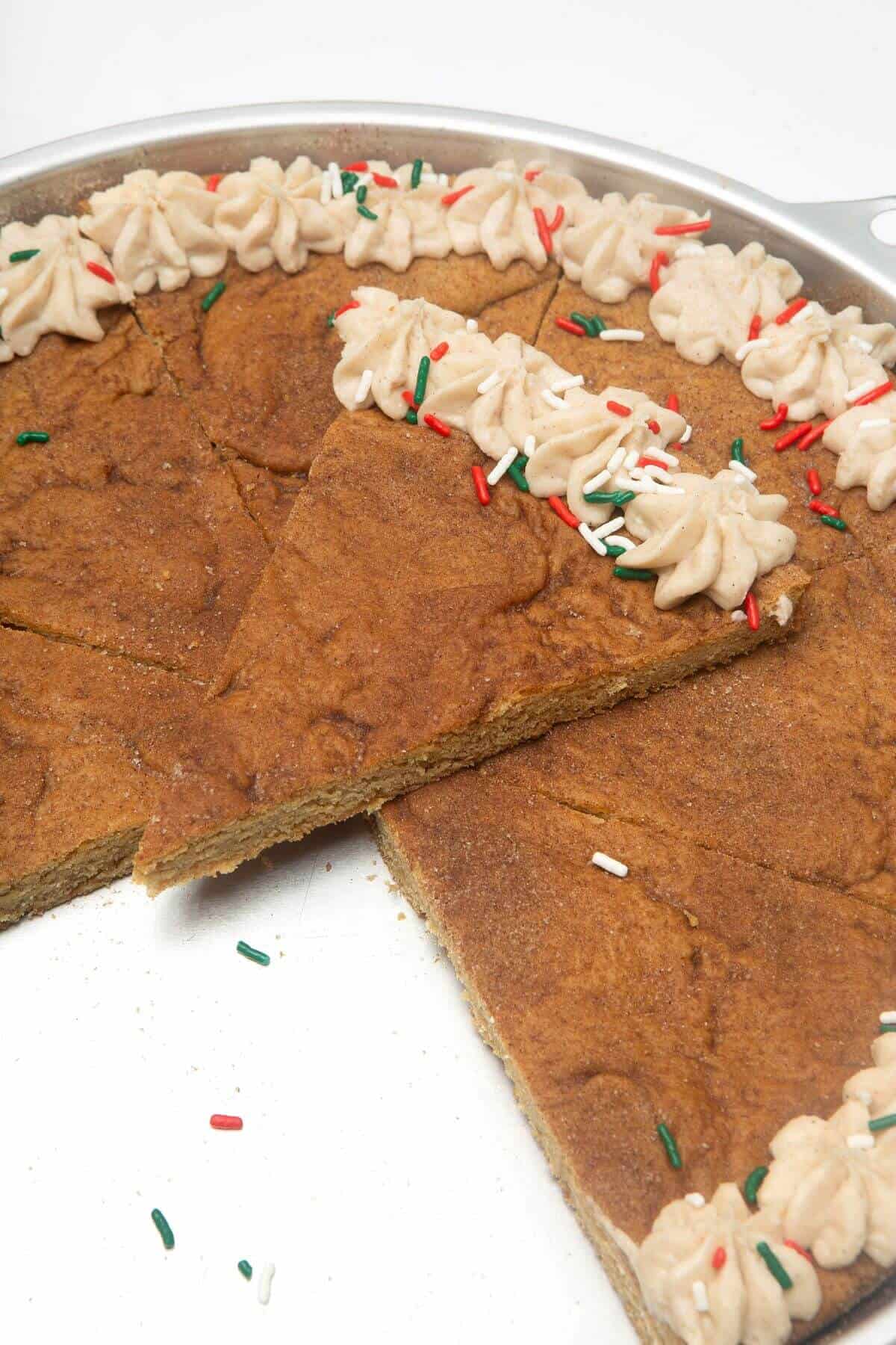 Snickerdoodle cookie cake sliced when one piece on top.