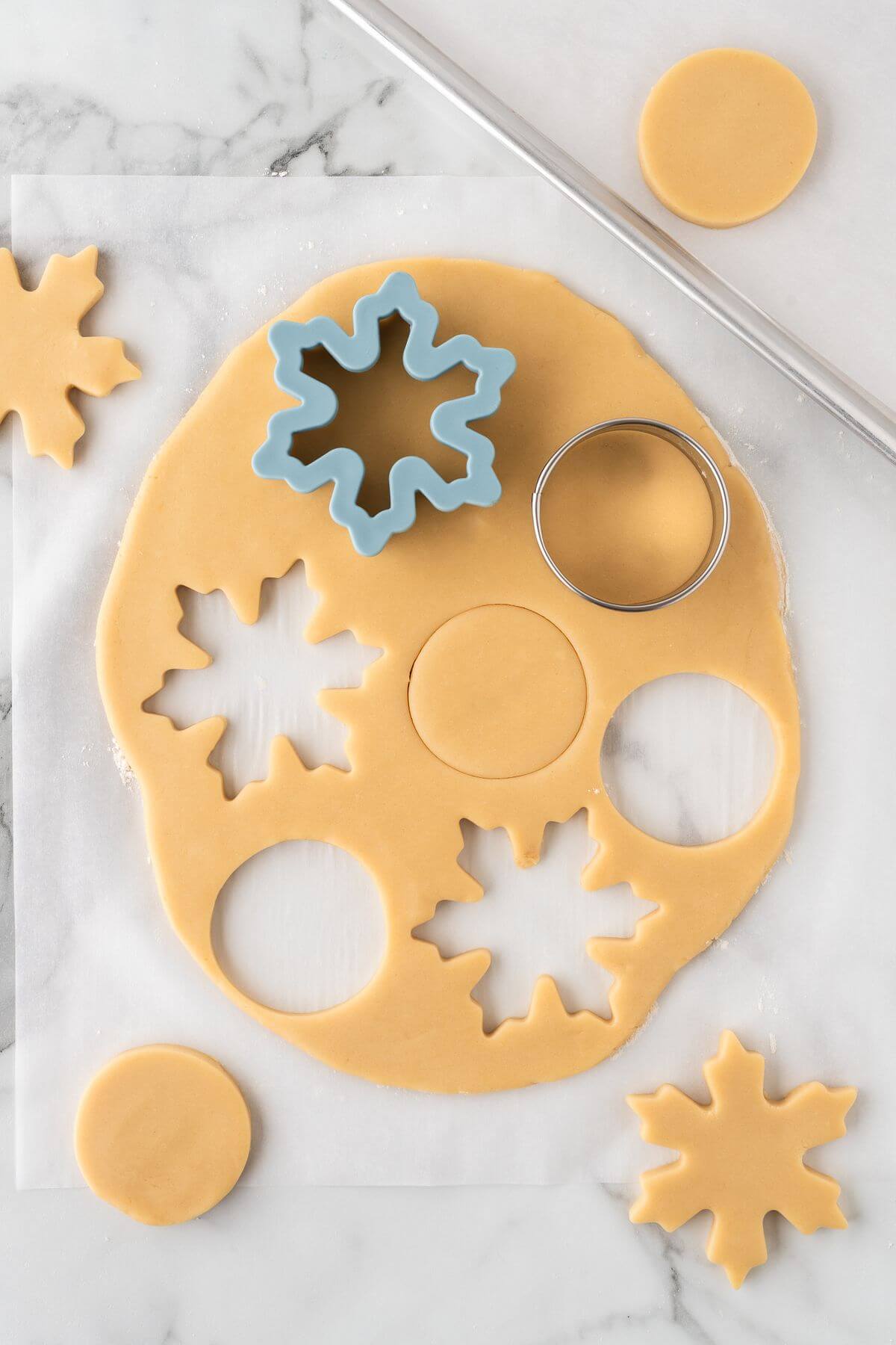 cutting out snowflake and circle cookie dough