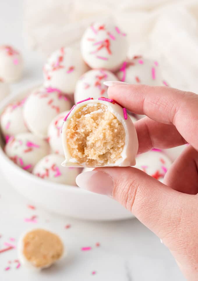 hand holding sugar cookie Valentine truffle with bite