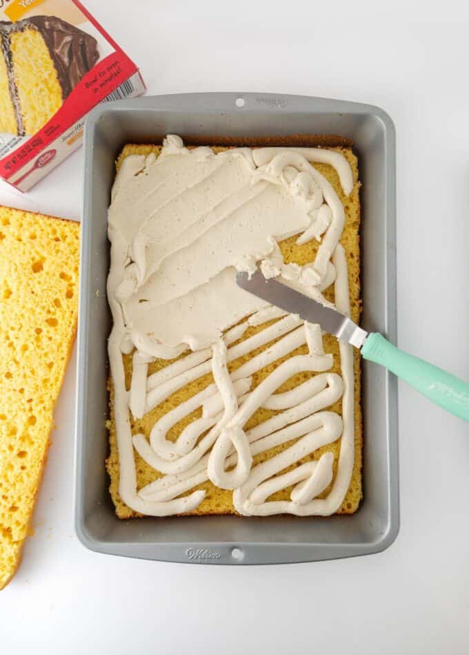 Overhead view of frosting being spread onto bottom half of zebra cake